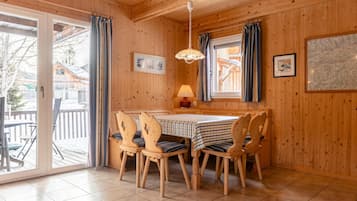 Un intérieur en bois avec une table et des chaises, une lampe et une carte accrochée au mur.