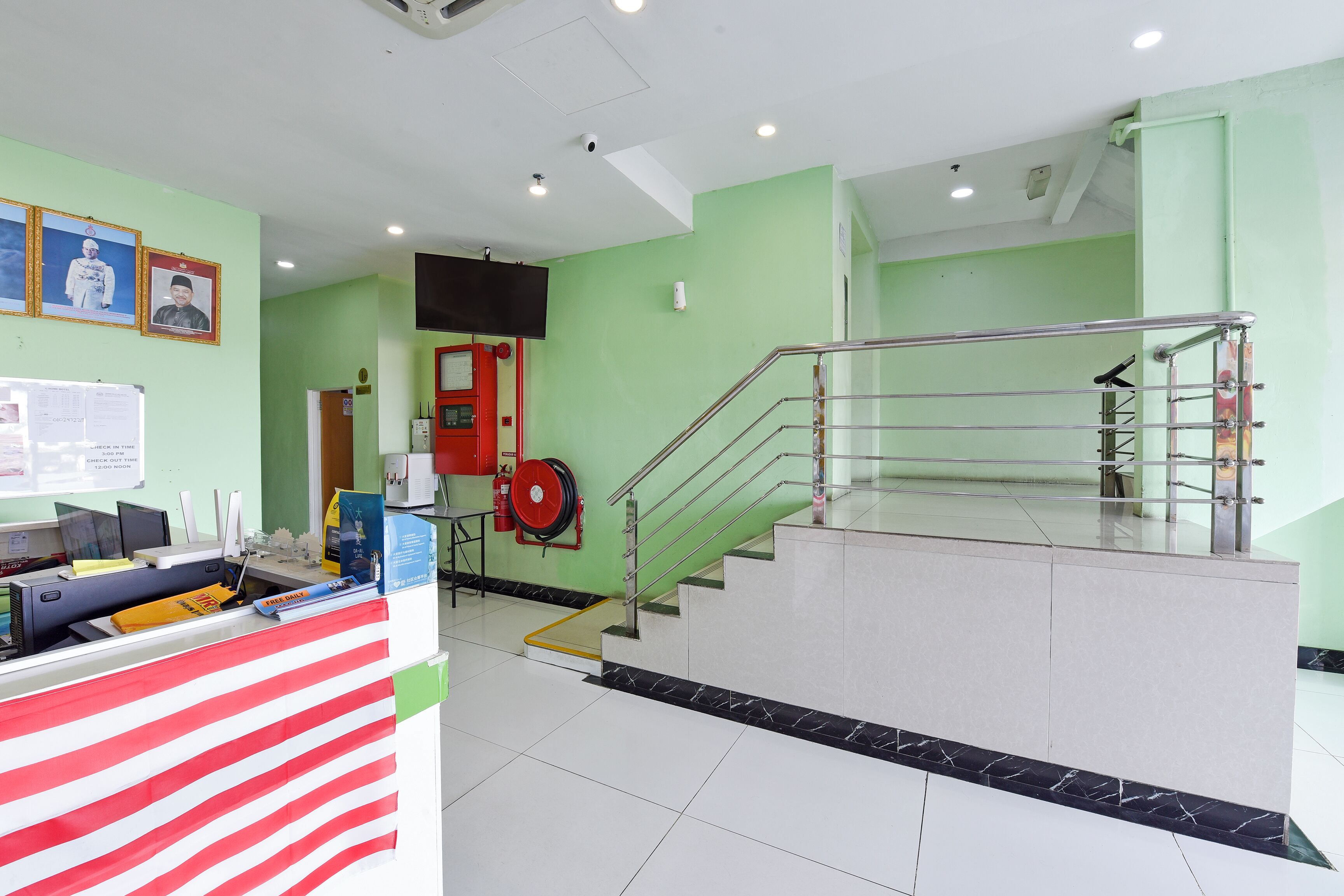 A reception area with a counter, a staircase, and a fire extinguisher.