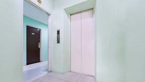 A hallway with a door marked 202, an elevator, and a tiled floor. - Hotel O G Home Hotel, Kota Bharu, Kelantan. (Kota Bharu)