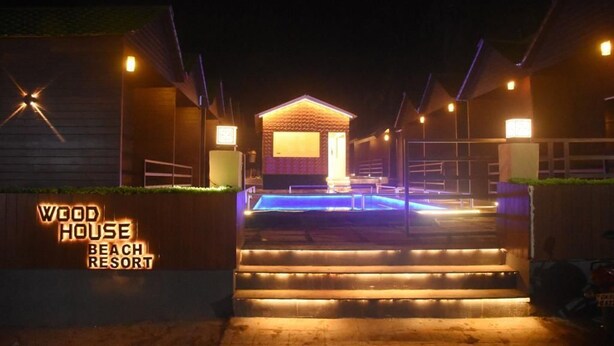Un edificio de madera con piscina, con la etiqueta 'Wood House Beach Resort'.
