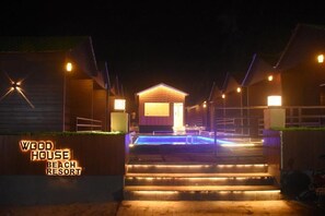 Un edificio de madera con piscina, con la etiqueta 'Wood House Beach Resort'.