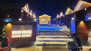 Entrada de un complejo turístico con un cartel que dice "WOOD HOUSE BEACH RESORT".