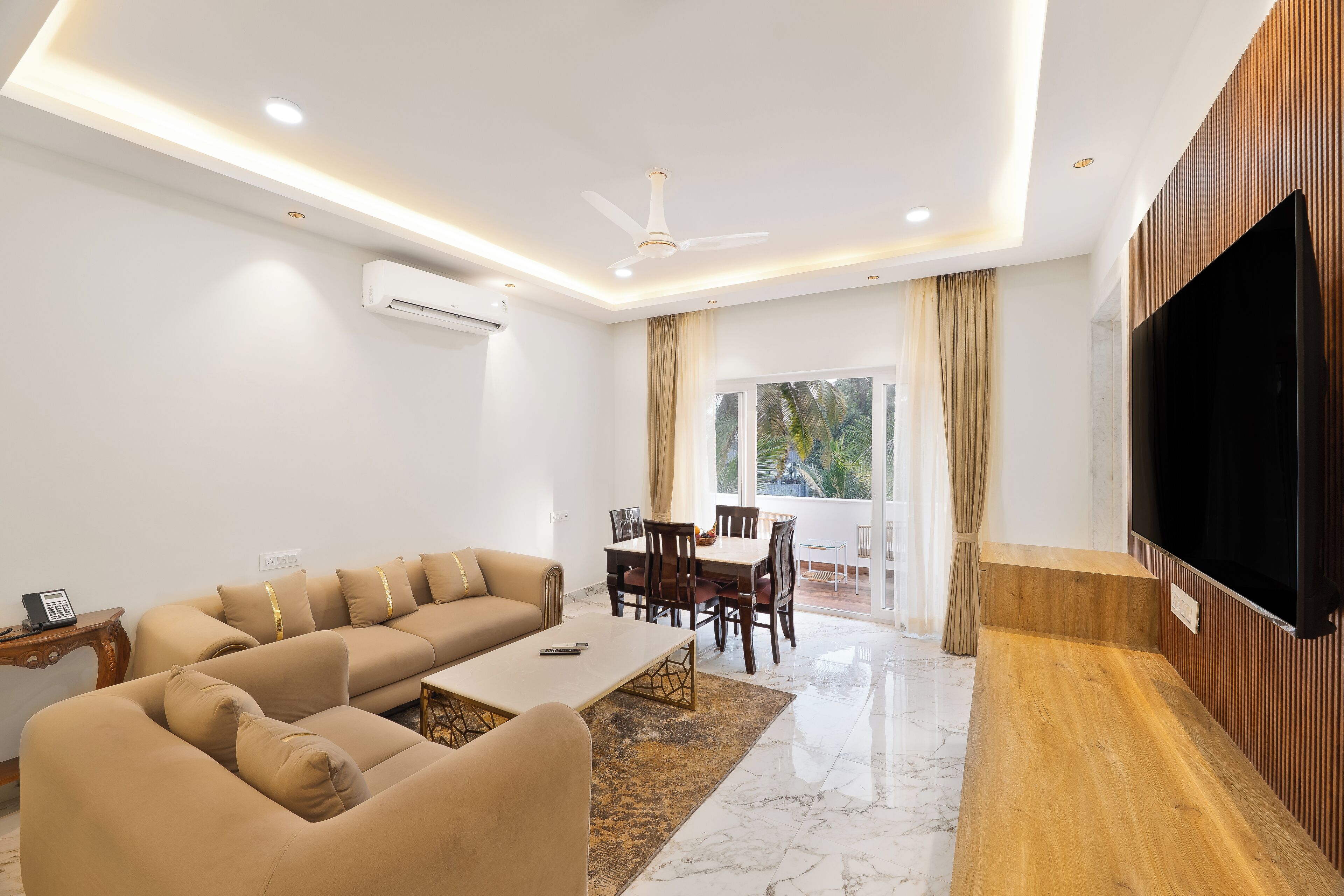 A modern living room with a sectional sofa, a dining table, and a flat-screen TV.