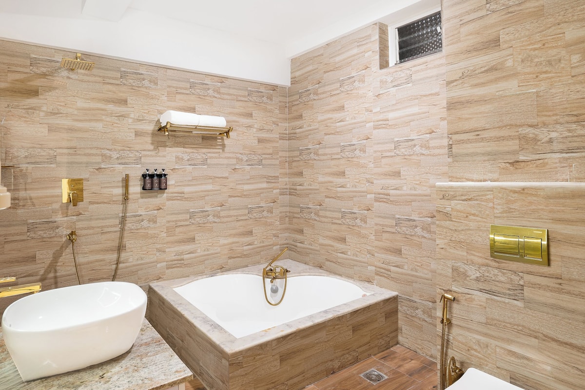 A modern bathroom with a freestanding bathtub, a toilet, and a vanity with a bowl sink.