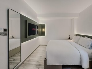A modern hotel room with a large bed, a wall-mounted TV, and a mirror. - The Concept Hotel HCMC - Premium (Ho Chi Minh City)