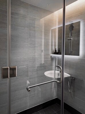 A modern bathroom with a glass shower enclosure, a sink, and a toilet. - The Concept Hotel HCMC - Premium (Ho Chi Minh City)