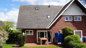 A two-story house with a brick facade, a tiled roof, and a small attached garage. - Holiday Home 'Sylthus-Haithabu' with Private Terrace, Private Garden and Wi-Fi (Wenningstedt)