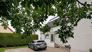 A car parked in a driveway with a white building in the background. - Holiday Home 'Haus Steinheim' with Shared Terrace, Garden, and Wi-Fi (Dillingen an der Donau)