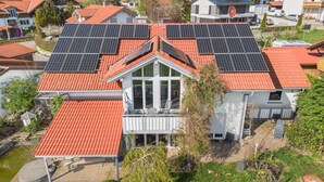 A residential building with a red-tiled roof, large windows, and solar panels. - Holiday Apartment 'Cosy Home Allgäu' with Mountain View, Balcony and Wi-Fi (Haldenwang)