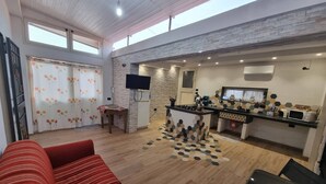 Amplia sala de estar con sofá, mesa de comedor y zona de cocina con isla central.