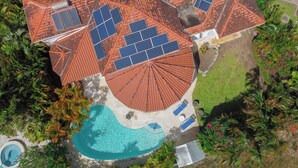 A residential property with a swimming pool, solar panels, and a well-maintained garden. - Marzalea - by Zenbreak (Paynes Bay)
