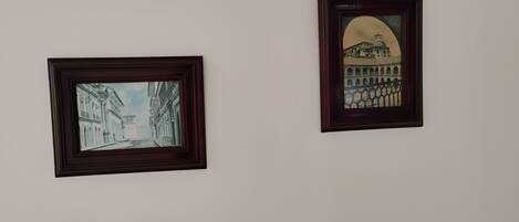 Two framed artworks on a plain wall.