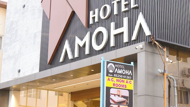 Een hotelschild met 'HOTEL AMOHA' en een bord dat 'Kamers met airconditioning, kamers zonder airconditioning' aangeeft, plus een mobiel telefoonnummer.