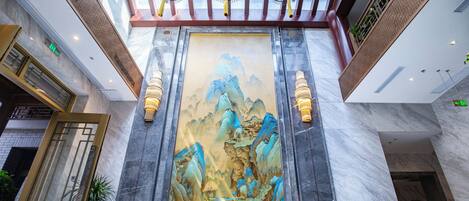 A large mural of a mountainous landscape in a hotel lobby.
