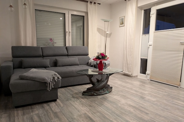 Wohnzimmer mit Schlafsofa und Eingangsbereich