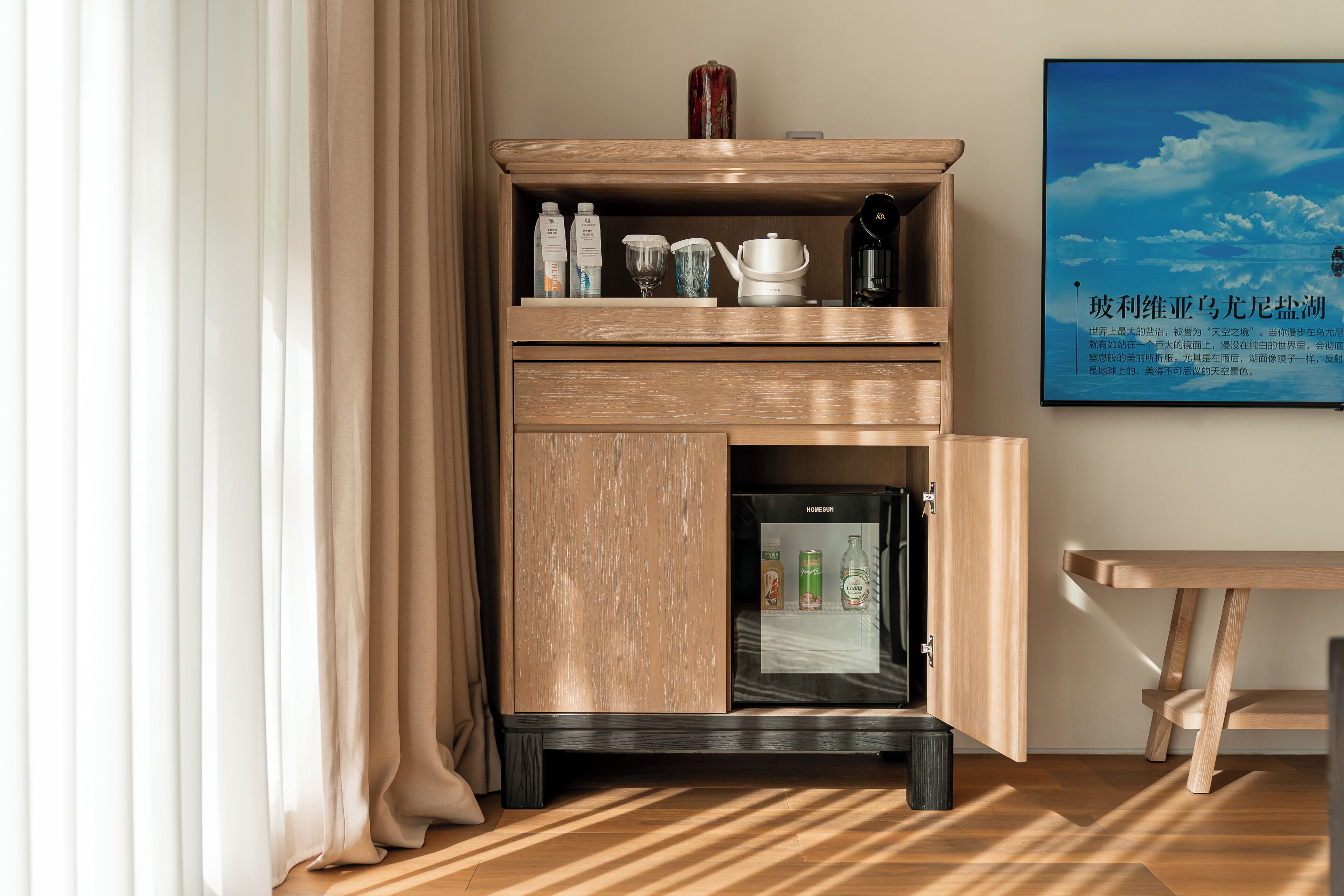 Un minibar con bebidas, una cafetera y un refrigerador.