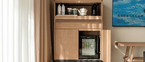 Un minibar con bebidas, una cafetera y un refrigerador.
