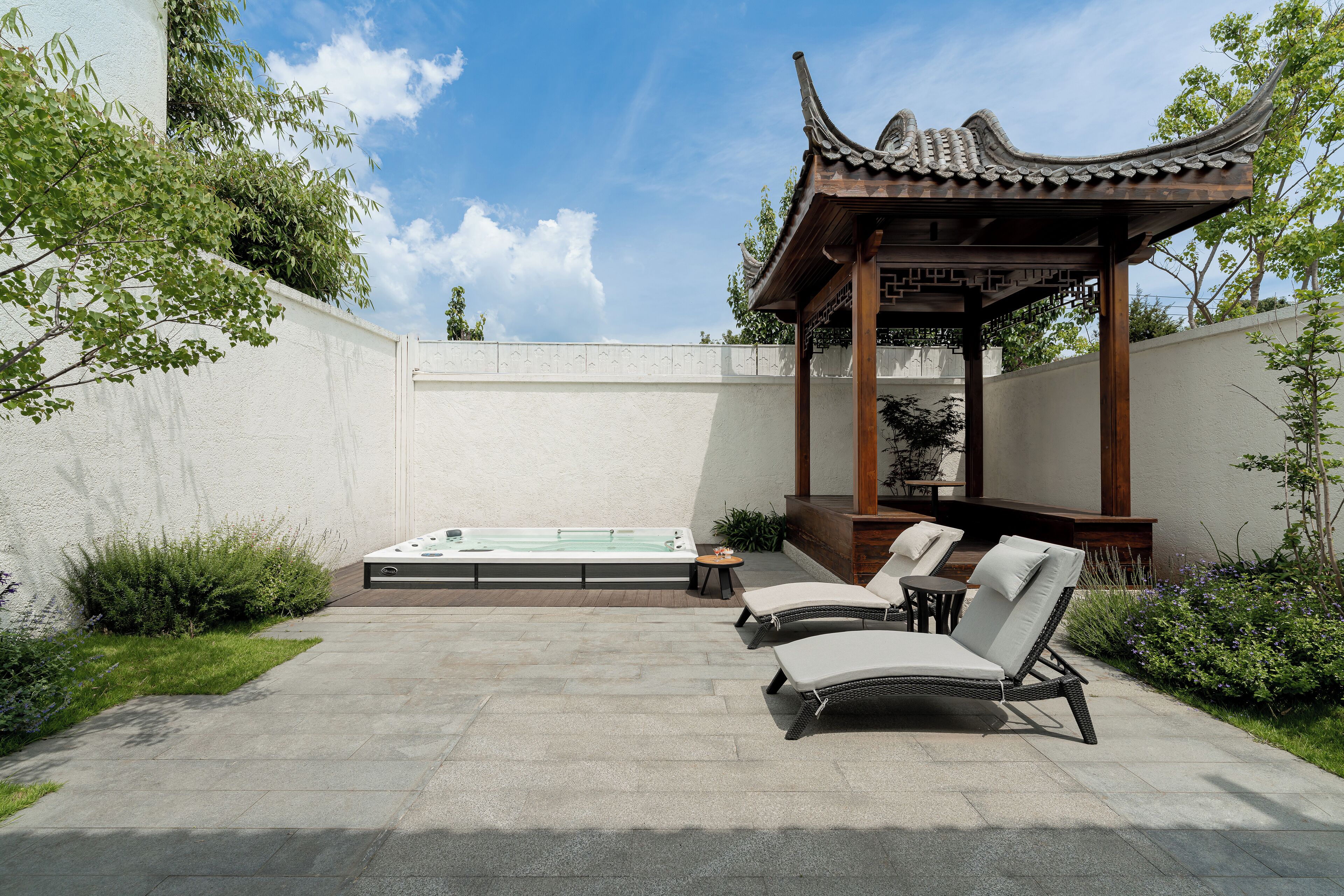 Un área de spa con un jacuzzi, sillones de descanso y un pabellón tradicional.