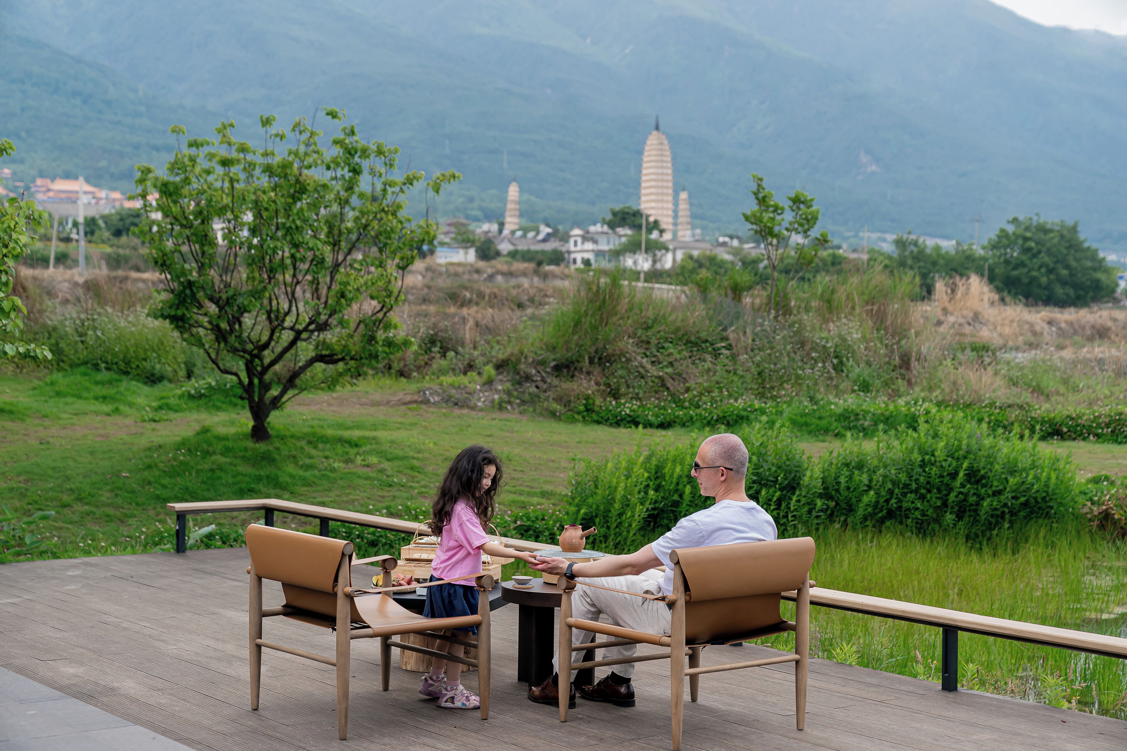 Ein Paar sitzt an einem Tisch im Freien mit Blick auf eine Berglandschaft.