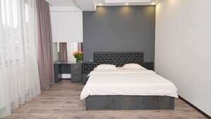 Une chambre à coucher moderne avec un grand lit, un bureau et une chaise.