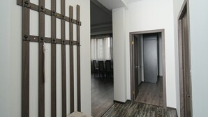 Un couloir avec une cloison faite de lattes de bois, une porte et une vue sur un coin repas.