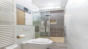 A modern bathroom with a glass-enclosed shower, a white toilet, and a towel rack. - Lovely studio for 2 people - Sentier (Paris)