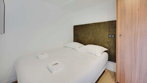Ein Hotelzimmer mit einem Bett, einem Holz-Kopfteil und einem Kleiderschrank.
