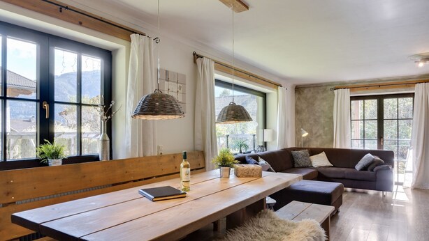 A cozy living room with a wooden bench, a sofa, and hanging lamps. - Chalet Leogang near Skilift & Bikepark (Leogang)