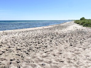 Een zandstrand met een heldere lucht.