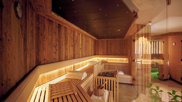 A wooden sauna with benches and a wooden bench in the center. - Vacation apartment Hochfelln, 1-6pers., 2 sep. 1st bedroom, 1st floor, east-facing balcony with lake & distant view (Chieming)