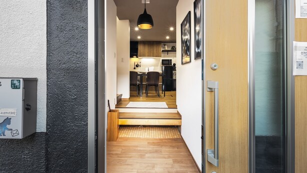 Un intérieur moderne avec une porte en bois, un petit coin cuisine et un espace repas.