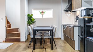Une cuisine compacte comprenant une table et des chaises, un four encastré et un four à micro-ondes.