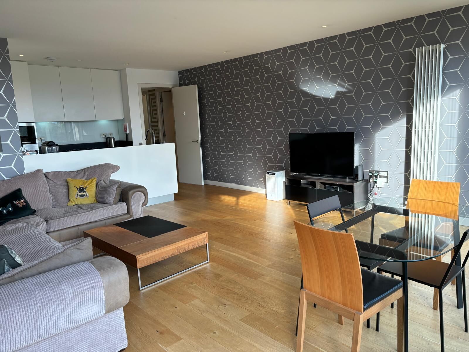 A modern living room with a sofa, coffee table, and dining area.