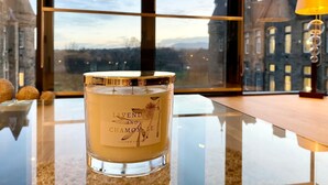 A candle labeled "Lavender and Chamomile" on a reflective surface with a view of buildings through a window. - Stunning Park View Quartermile Apartment Close Proximity to Castle & University (Edinburgh)