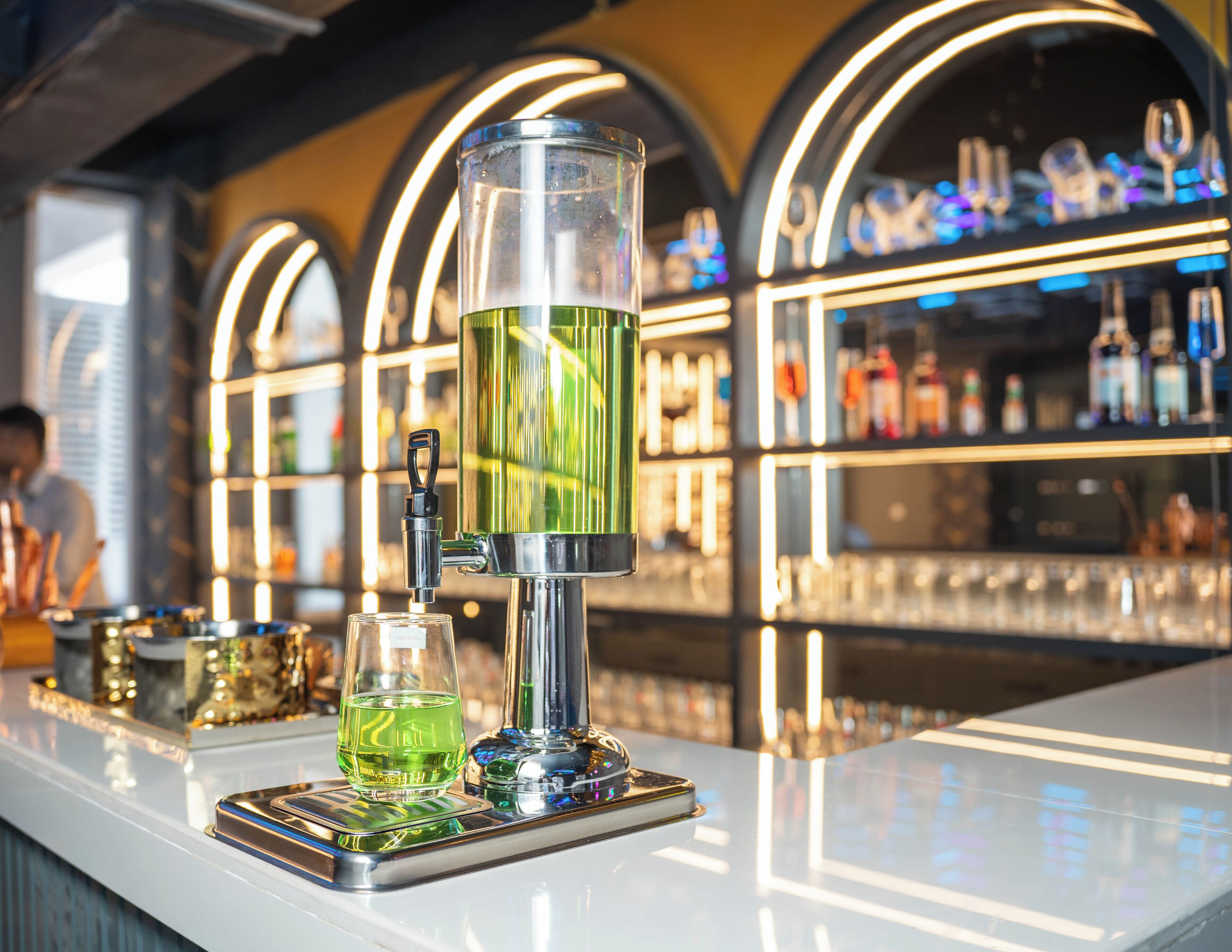 Un bar con una grifería moderna y cristalería.