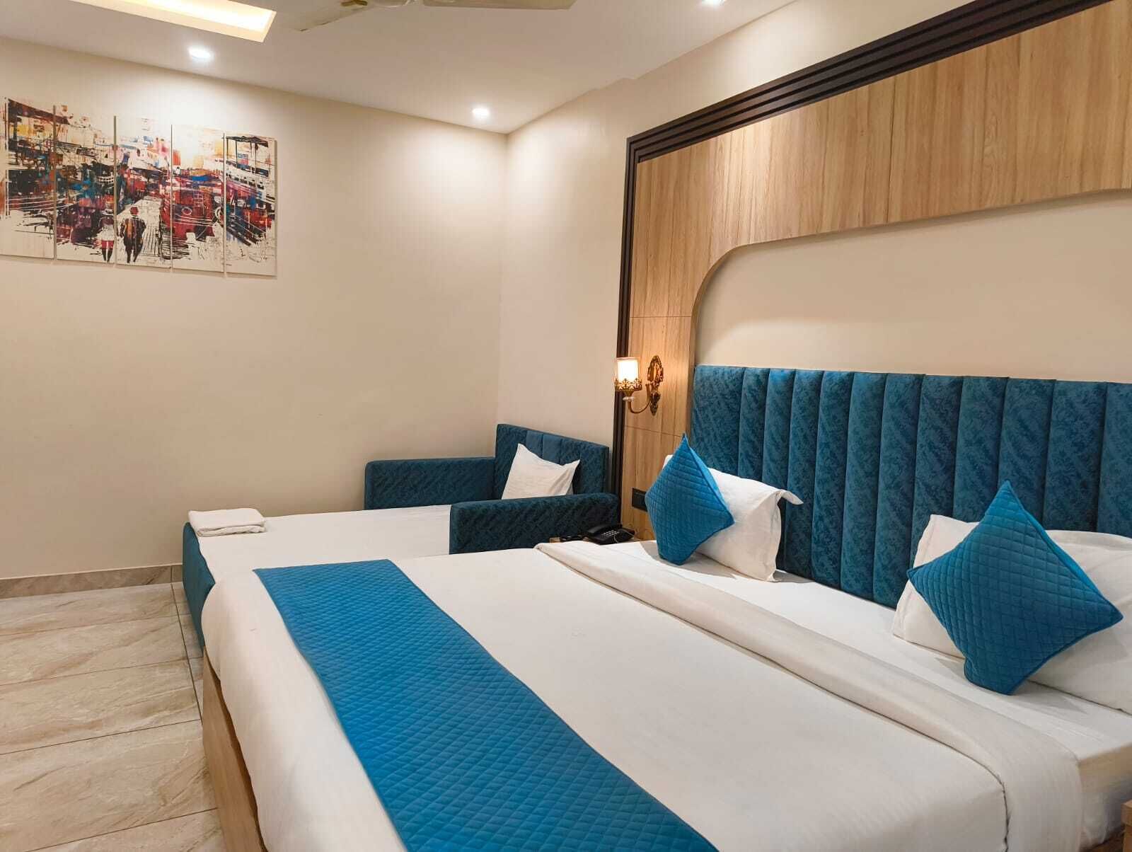 A hotel room with a large bed, two bedside tables, a headboard, and a wall-mounted artwork.