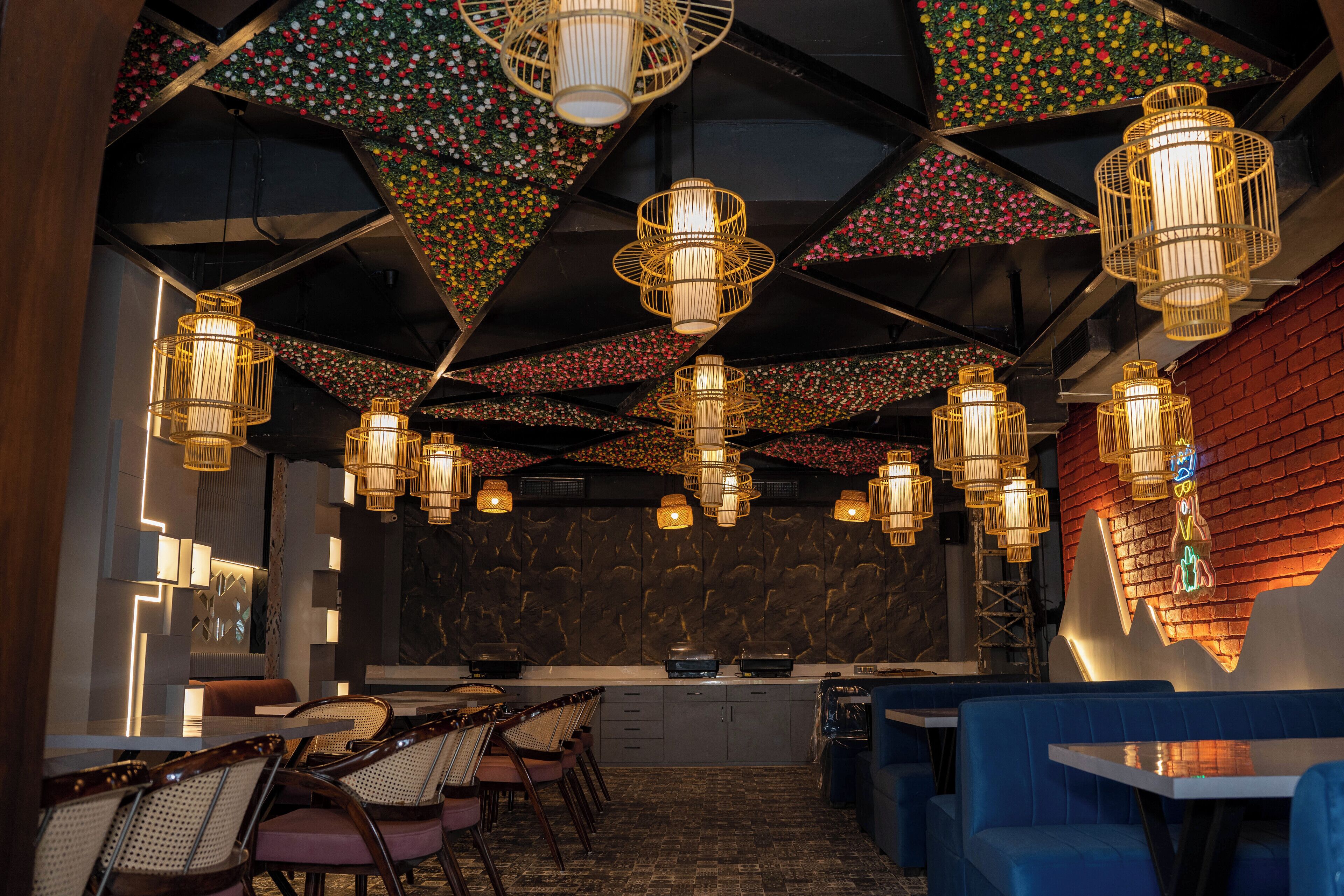 Een restaurant met meerdere tafels en stoelen, hangende吊灯 en een bakstenen muur.