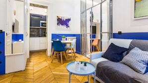 A modern living space with a dining area, a sofa, and a small table with plants. - Moderne apartment - 1BR/4P - AC - Champs-Élysées (Paris)