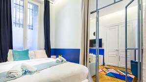 A hotel room with a bed, a bathroom, and a view of the city. - Moderne apartment - 1BR/4P - AC - Champs-Élysées (Paris)