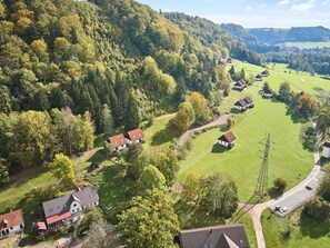 An aerial view of a rural area with several houses surrounded by lush greenery and hills. - Green Valley Park Stárkov 5 by Interhome (Stárkov)