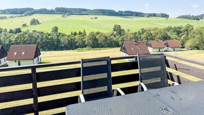 A terrace with a view of a green field and houses. - Green Valley Park Stárkov 17 by Interhome (Stárkov)