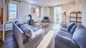 A modern living room with a sofa, a small table, a TV, a fireplace, and a bookshelf. - Green Valley Park Stárkov 20 by Interhome (Stárkov)