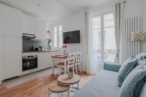 A modern apartment with a kitchen, dining area, and living room.