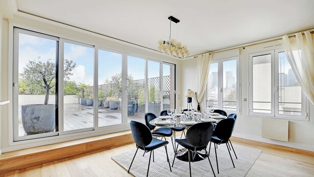 A dining area with a table set for six, large windows, and a view of the outdoors. - Stunning apartment - 3BR/6P - La DÃ©fense (Courbevoie)