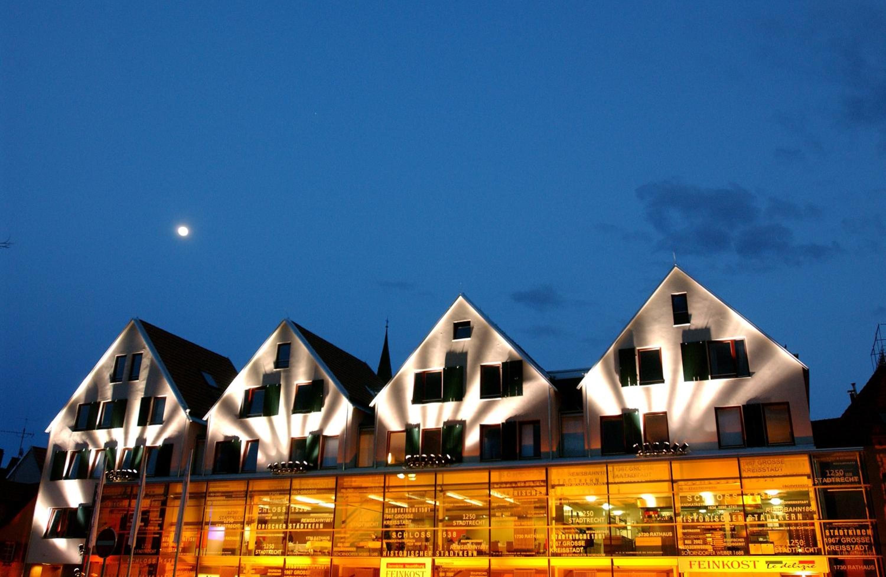 A row of modern, triangular-roofed buildings with large windows, likely a hotel or commercial complex.