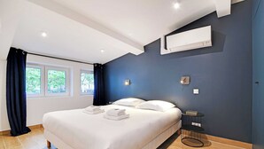 A modern hotel room with a large bed, a small side table, and a window with curtains. - Welcoming apartment -1BD/4P - 18th arrd (Paris)
