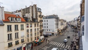 A street view with buildings, a crosswalk, and vehicles. - Cosy apartment - 4P - Place de la Bastille (Paris)