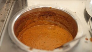 A metal container with a thick, orange sauce. - Atithi Hotel and Dhaba (Panipat)