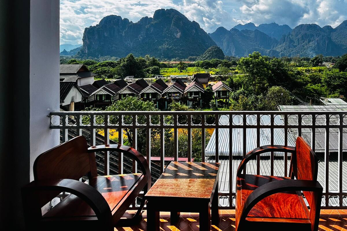 A balcony with a view of traditional houses and mountains.