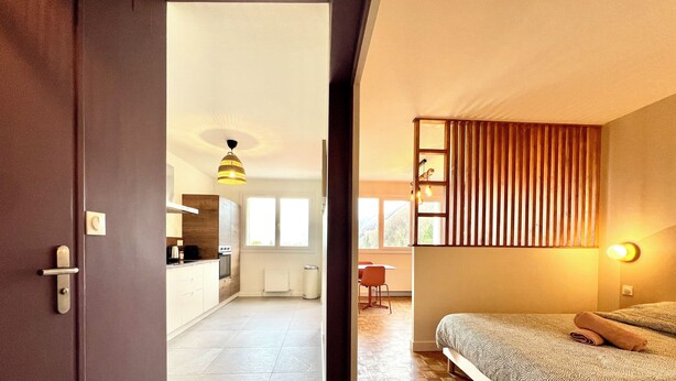 Una habitación de hotel moderna con una cama, un escritorio y vistas a la cocina.